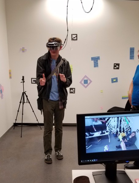 I try out a few hand gestures to select data in augmented reality. You can see my view in the bottom left.
