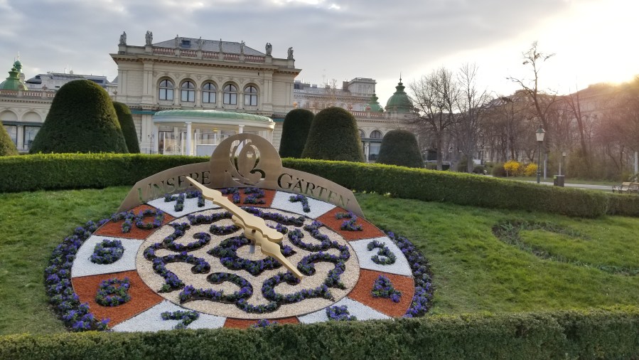 The Kursalon music hall as viewed in Stadtpark. The clock in the hedge says "Our Garden."
