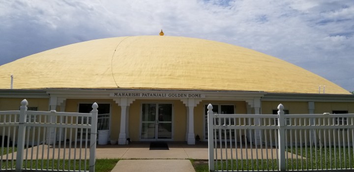 A view of the entrance to a Golden Dome labeled "Maharishi Patanjali Golden Dome."